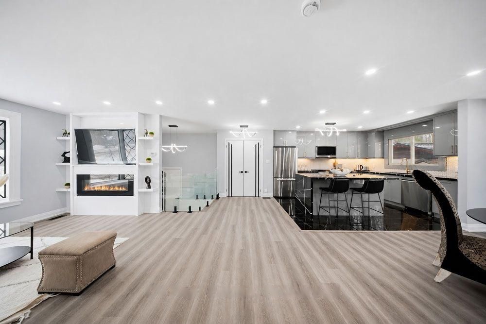 Open-concept main floor with the living room, kitchen and fireplace wall