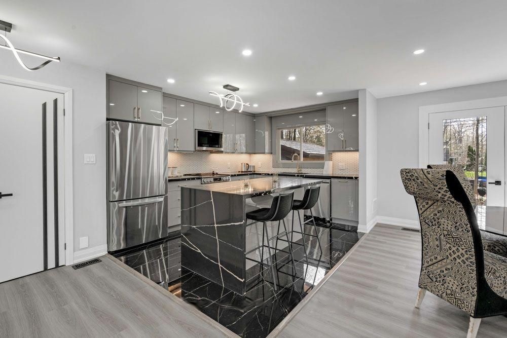 Waterfall kitchen island with bar seating and stainless steel appliances