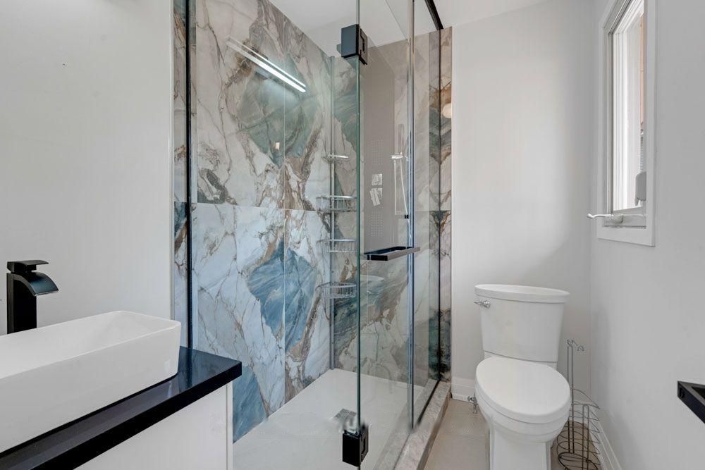 Bathroom with a glass shower and a marble-look feature wall