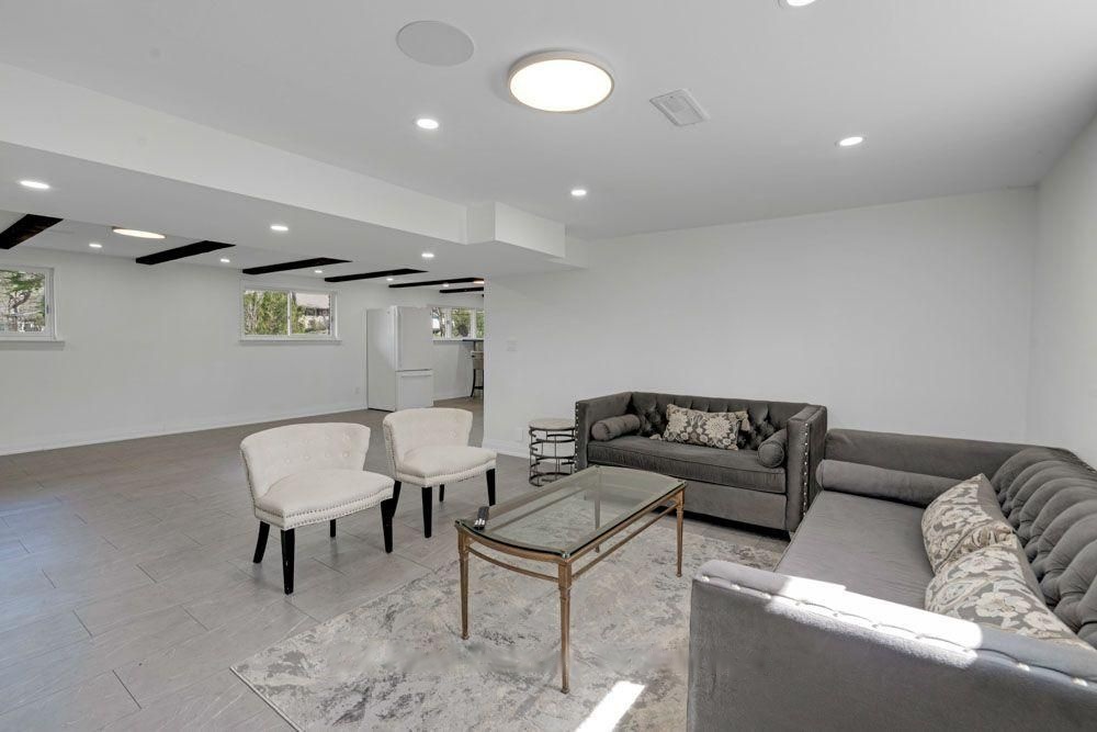 Lower-level family room with tile flooring and recessed lighting
