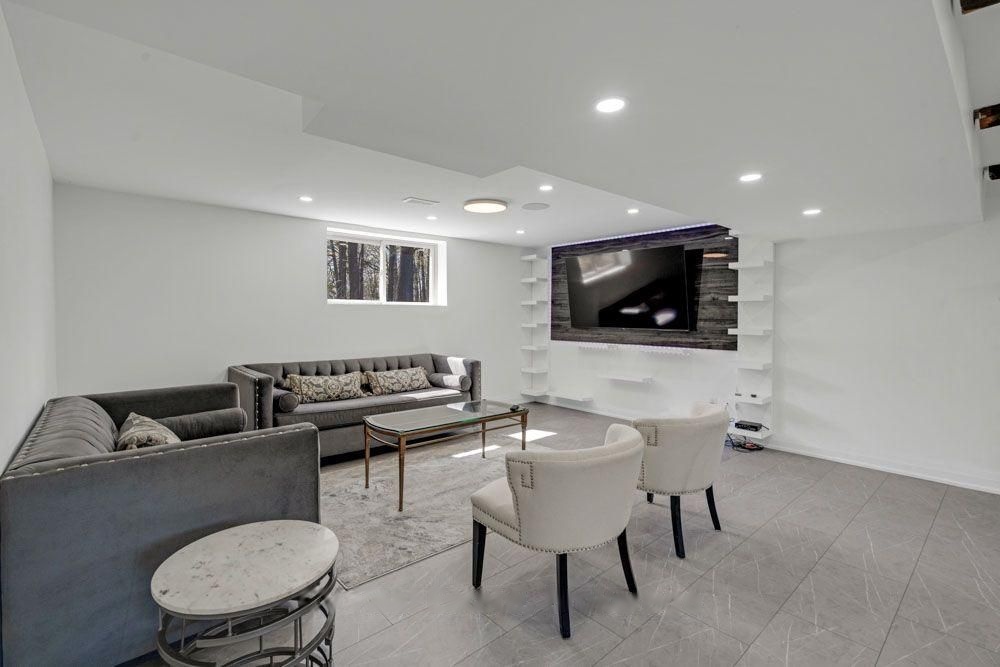 Lower-level lounge with a wall-mounted TV and floating shelves
